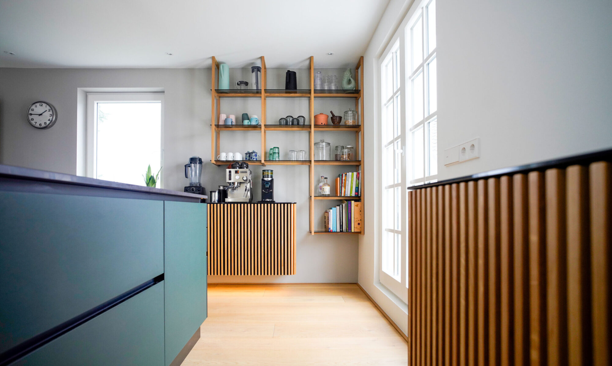 Designküche mit weißen Silestone-Flächen, handgeschöpften Fliesen und Nußbaumfronten in Stuttgart.
