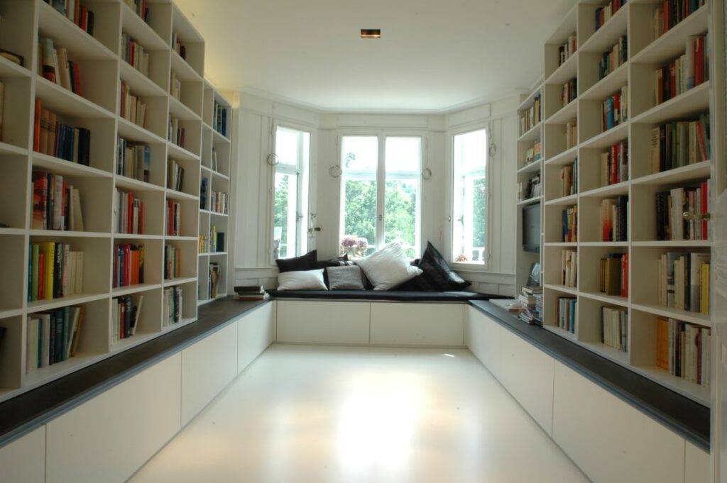 Bibliothek mit viel Stauraum und gemütlicher Leseecke am Fenster