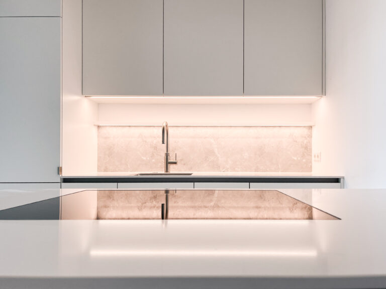 Weiße Küche mit Kochtheke mit eingelassenem Kochfeld