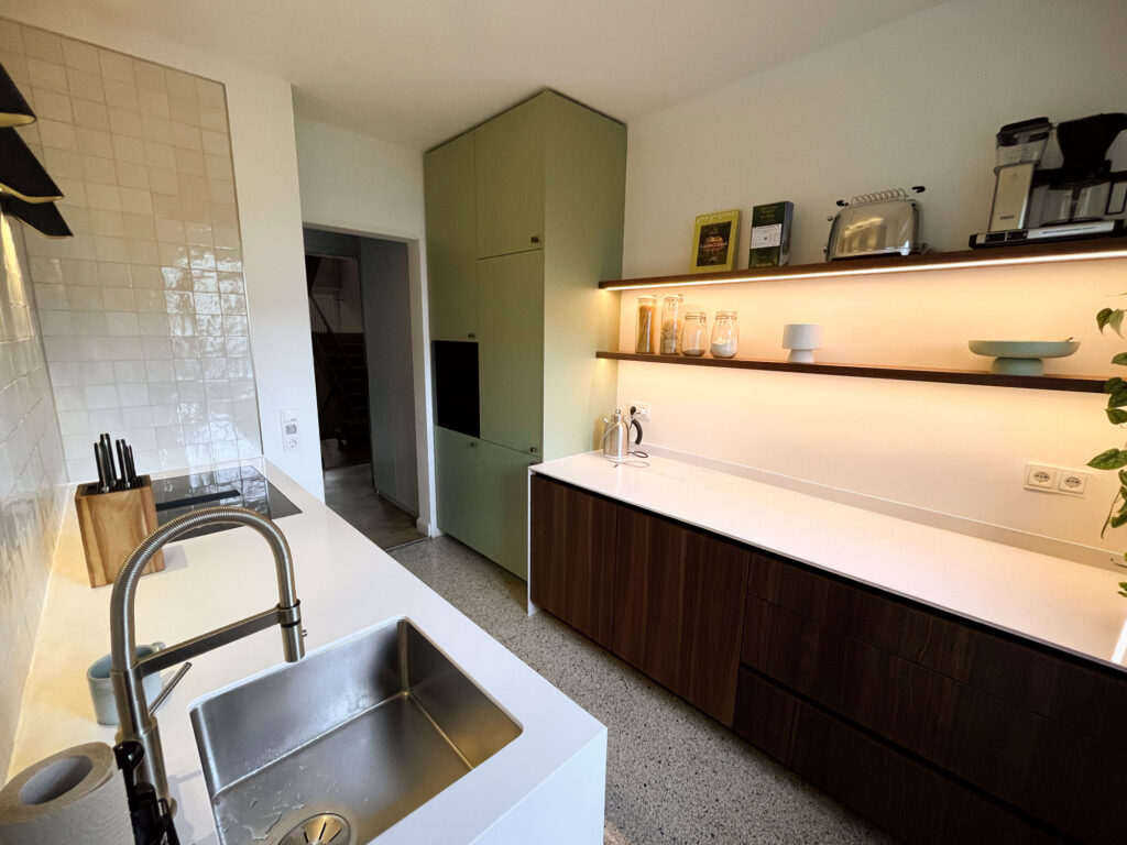 Stilsicheres Raumwunder – die rückversetzen beleuchteten Regale, die Silestone-Oberflächen und die zarten reflektierenden Fliesen betonen die Waagrechte und öffenen und vergrößern die Designküche