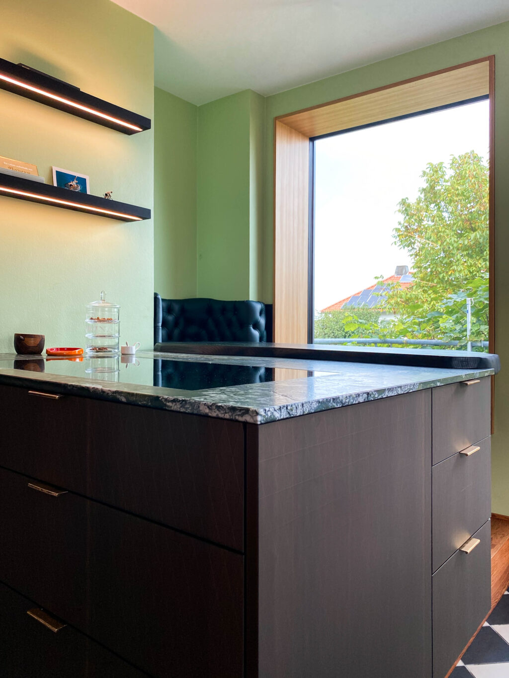 Küche mit gepolstertem Sitzfenster und Nische an schwarzer Echentheke mit Naturkante