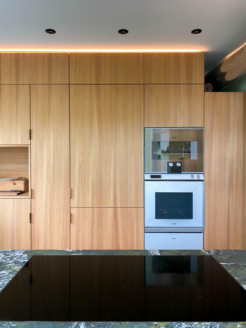 Klare Ordnung - Küchenschrank aus Eiche mit Geräten in Griffweite von der Kücheninsel.