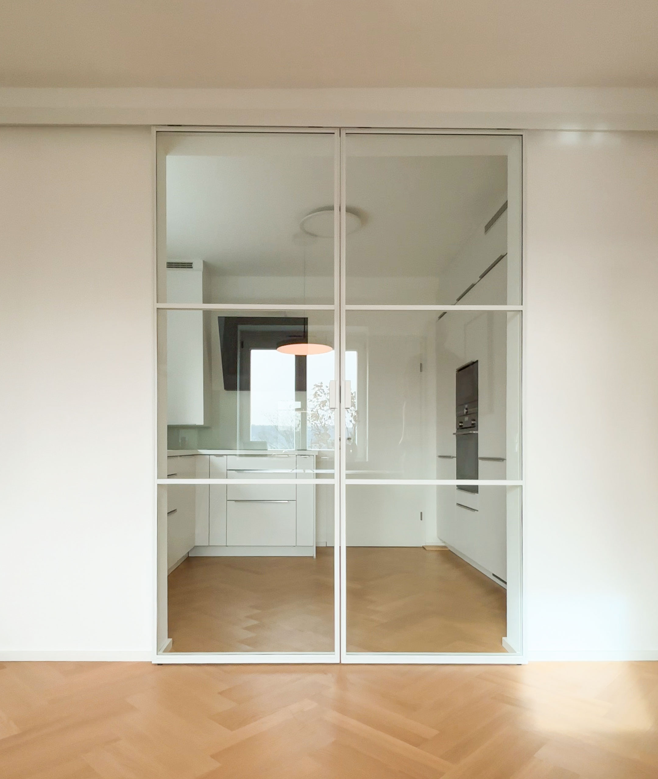 Flexibel: mit der Doppel-Schiebetür im Loftstil kann die Küche zugemacht werden ohne Licht und Weite zu verlieren.