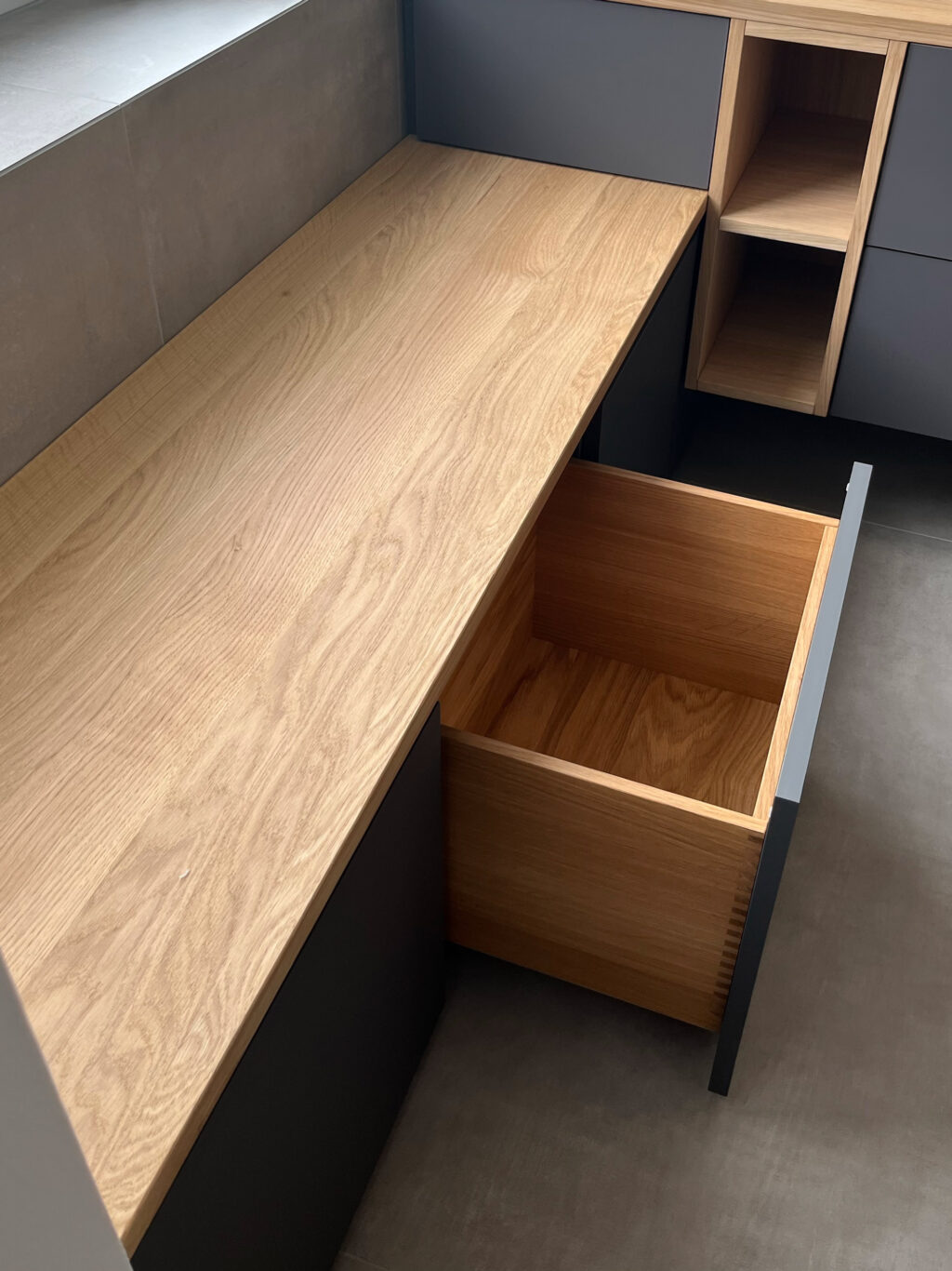 Doppelwaschtisch in Eiche und Fenix mit Sitzbank im Bad – Wellness-Atmosphäre durch klare Linien und Naturmaterialien.