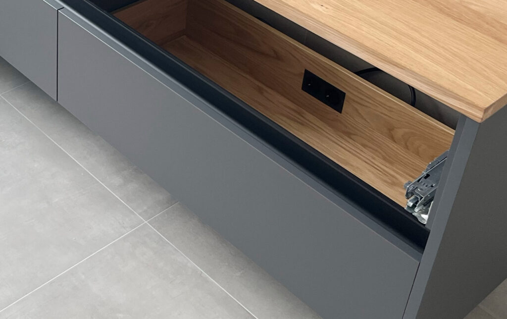 Schublade mit integrierten Steckdosen für Haartrockner und Stylinggeräte – durchdachte Stauraumlösung im Badezimmer.