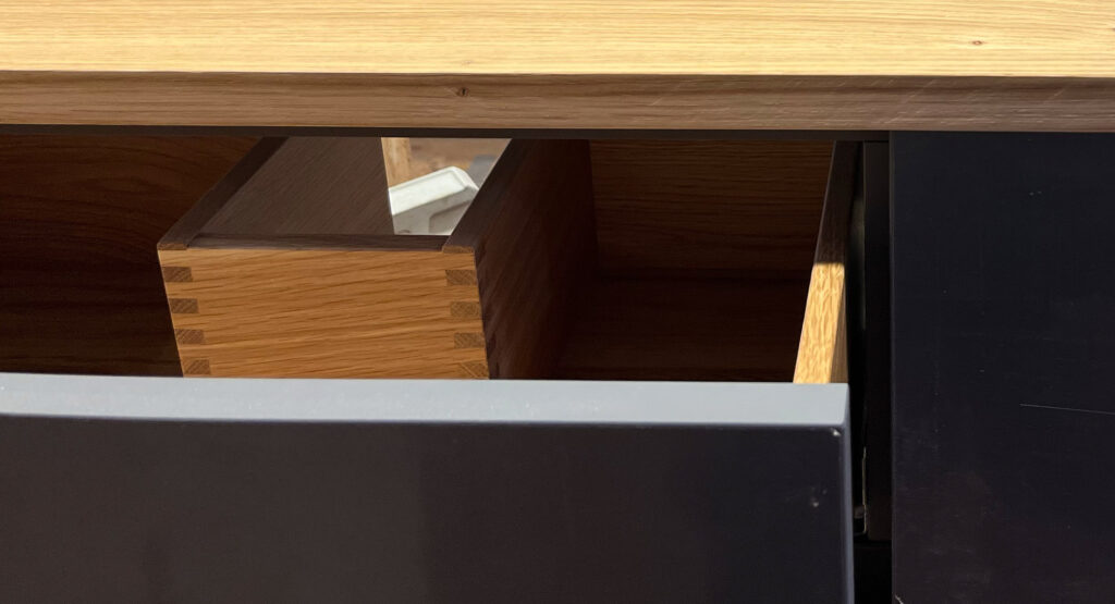 Eichen-Schublade mit präzisem Siphonausschnitt – maximale Stauraumnutzung trotz Waschbecken.