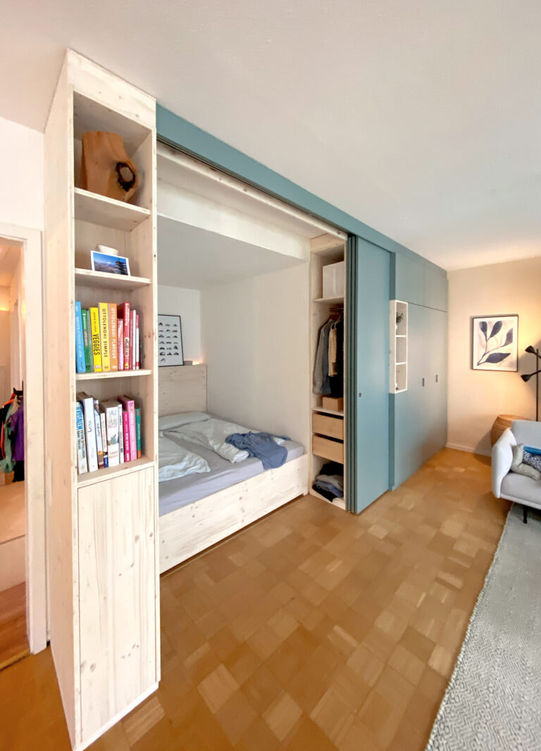 Eine Bettnische im Wohnzimmer versteckt hinter Schiebetüren
